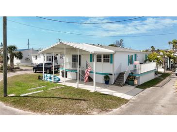 Charming coastal home with a covered carport and porch, accented with turquoise trim at 2601 Gulf N Dr # 427, Bradenton Beach, FL 34217