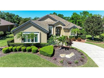 Beautiful single-story home with a well-manicured front yard, lush landscaping, and a long driveway at 5304 96Th E St, Bradenton, FL 34211