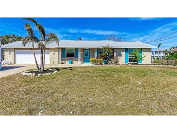 Charming single-story home featuring a lush front lawn and coastal accents at 609 Foxworth Ln, Holmes Beach, FL 34217