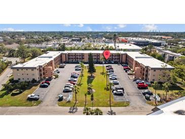 A three-story condominium community with well-maintained landscaping and ample parking at 4126 Heron Way # B113, Bradenton, FL 34205