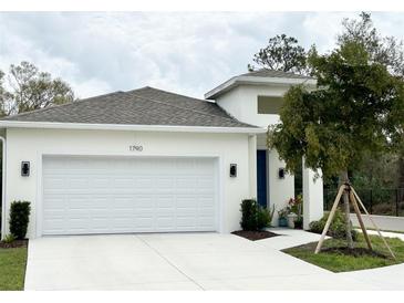 Charming one-story home featuring a two-car garage, modern design, and landscaping at 1790 White Orchid Ct, Sarasota, FL 34235