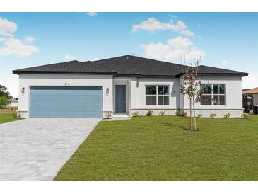 Beautiful single-story home with a well-manicured lawn, blue garage door, and bright white paint at 514 Santiguay St, Punta Gorda, FL 33983
