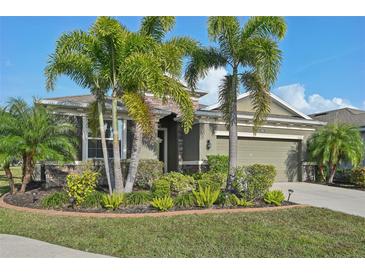 Charming one-story home with a well-manicured lawn and lush tropical landscaping at 7812 Birdie Bend Way, Sarasota, FL 34241