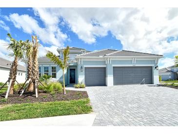 Charming single-Gathering home features a two-car garage, landscaped front yard with palm trees, and beautiful blue skies at 12440 Meribel St, Venice, FL 34293