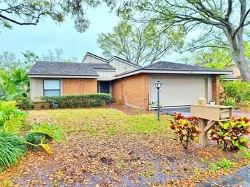 Charming brick home features a two-car garage, mailbox, and lush landscaping in the front yard at 1407 Willow Oak Cir, Bradenton, FL 34209