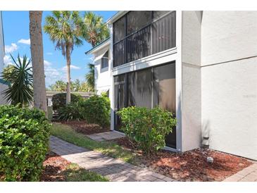 Attractive condo featuring a ground floor screened-in patio and mature landscaping at 5641 Midnight Pass Rd # 903, Sarasota, FL 34242