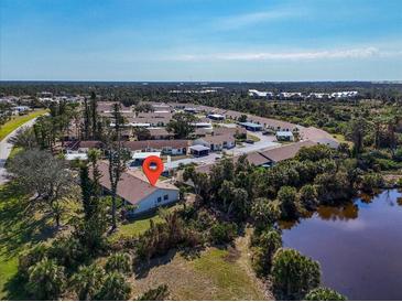 A lovely aerial view of a well-maintained community near a pond and lush trees at 6796 Gasparilla Pines Blvd # 45, Englewood, FL 34224