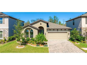 Charming single-story home featuring a well-manicured lawn, a two-car garage, and beautiful landscaping at 12750 Oak Hill Way, Parrish, FL 34219
