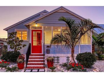 Charming home with a bright red door, complemented by lush landscaping and a quaint, inviting appeal at 310 S Osprey Ave, Sarasota, FL 34236