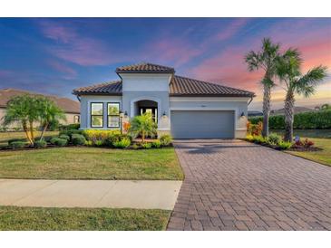 Charming single-story home with lush landscaping, paver driveway, and a tile roof at 4543 Terrazza Ct, Lakewood Ranch, FL 34211