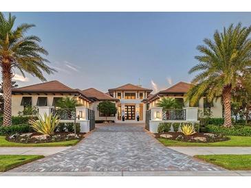 Stunning home featuring lush landscaping, a circular driveway, and a grand entrance at 14733 Como Cir, Lakewood Ranch, FL 34202