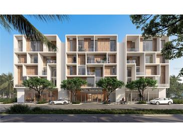 Modern condominium exterior with sleek design, private balconies, and manicured trees at 430 Kumquat Ct # 206, Sarasota, FL 34236
