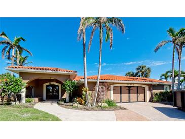 Beautiful home exterior featuring a tile roof, double garage, lush landscaping, and a well-manicured lawn at 542 67Th St, Holmes Beach, FL 34217