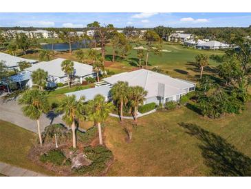 Beautiful home featuring a well-maintained yard, mature palm trees, and golf course view at 276 Cerromar Way # 60, Venice, FL 34293
