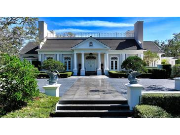 Elegant home exterior boasts manicured landscaping, striking columns, and a welcoming double door entrance at 101 Osprey Point Dr, Osprey, FL 34229