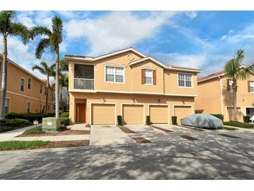 Charming townhome with three garage spaces, stucco facade, and tropical landscaping with palm trees at 3823 Parkridge Cir # 1-101, Sarasota, FL 34243