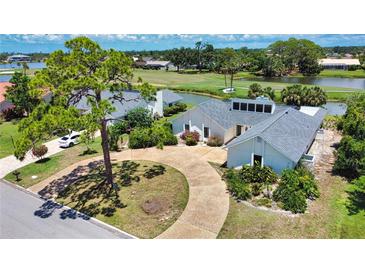 Well-maintained single-Gathering home on a landscaped lot with circular driveway and serene water views at 3837 Torrey Pines Blvd, Sarasota, FL 34238