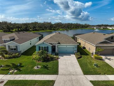 Inviting single-story home with a well-manicured lawn and serene water view at 3945 Mossy Limb Ct, Palmetto, FL 34221