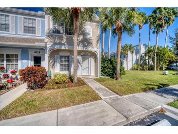 Charming townhome with well-kept lawn, sidewalk, and beautiful palm trees in the front yard at 4717 Sabal Key Dr, Bradenton, FL 34203