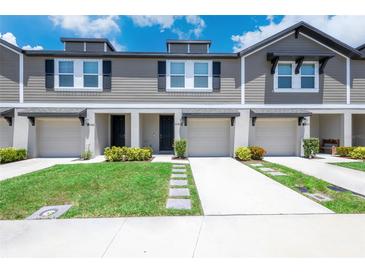 Inviting townhomes with attached garages, well-maintained lawns, and stone walkway at 17136 Blowfish Dr, Nokomis, FL 34275