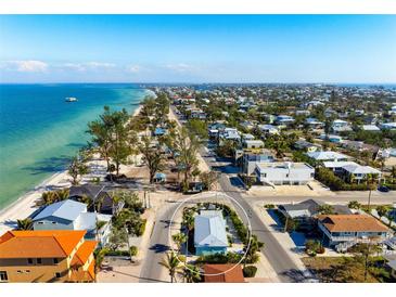 Aerial view of the turquoise beach house in a coastal community near the ocean at 912 N Shore Dr, Anna Maria, FL 34216
