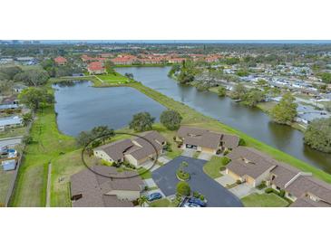 Aerial view of waterfront townhome community with mature landscaping and tranquil lake at 3119 Glen Elyn Blvd # 9, Sarasota, FL 34237