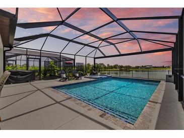 Sparkling screened pool with spa and poolside seating with lake views create a relaxing backyard oasis at 11419 Gallatin Trl, Parrish, FL 34219