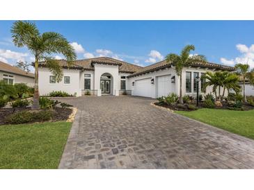 Beautiful one-story home featuring a paver driveway, well-manicured lawn and tropical landscaping at 14803 Derna Ter, Bradenton, FL 34211