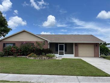 Charming single-story home featuring a well-maintained lawn, colorful flower beds, and an attached two-car garage at 4509 30Th Street E Cir, Bradenton, FL 34203
