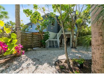 Charming home with white gravel yard and lush landscaping provides a tranquil setting at 5250 Calle De Rio, Sarasota, FL 34242
