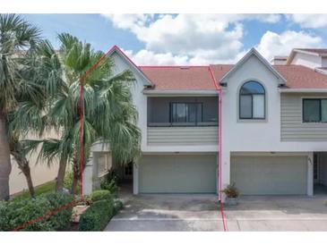 Inviting two-story townhome with attached garage and mature landscaping at 625 Duchess Blvd, Dunedin, FL 34698