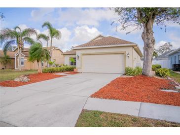 Charming single-story home featuring a manicured lawn, palm trees, and a spacious two-car garage at 7113 52Nd E Dr, Bradenton, FL 34203