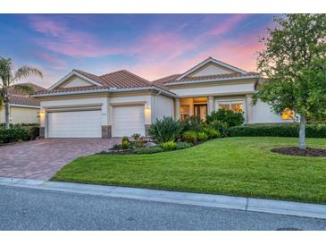 Charming single-story home with a well-manicured lawn, lush landscaping, and a three-car garage at 8284 Barton Farms Blvd, Sarasota, FL 34240