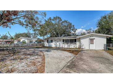 Charming single-story home with a spacious driveway and classic white exterior nestled under mature trees at 3365 7Th St, Sarasota, FL 34237