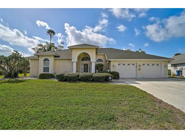Inviting single-story home with a well-manicured lawn, a three-car garage, and an elegant arched entryway at 4306 Presidential Avenue E Cir, Bradenton, FL 34203