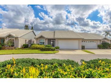 Well-maintained single-story home with attached garage, lovely landscaping, and a white tile roof at 5320 Crestlake Blvd # 26, Sarasota, FL 34233