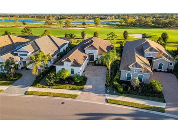 Stunning aerial view of a well-manicured home overlooking lush green golf course and serene blue lakes at 15520 Castle Park Ter, Lakewood Ranch, FL 34202