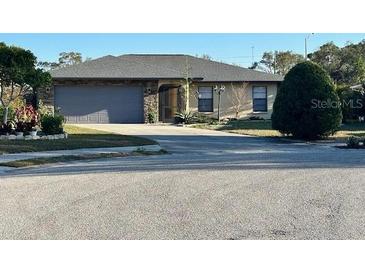 Charming single-story home with stone accents, a well-maintained lawn, and an attached two-car garage at 1842 Country Meadows Ct, Sarasota, FL 34235