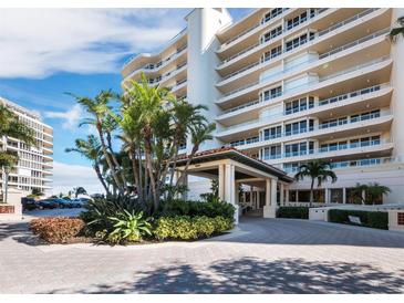 Luxury condominium exterior with lush landscaping, covered entrance, and circular driveway at 3010 Grand Bay Blvd # 482, Longboat Key, FL 34228
