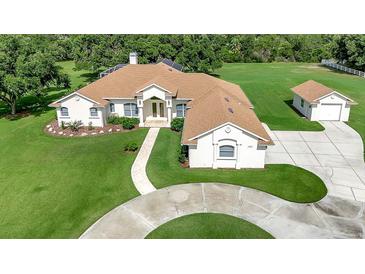 Expansive single-story home featuring a circular driveway and lush landscaping at 5750 Saddle Oak Trl, Sarasota, FL 34241
