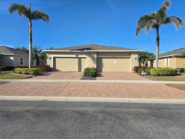Charming paired villa featuring a brick drive, two-car garage, and manicured landscaping at 13602 Abercrombie Dr, Englewood, FL 34223