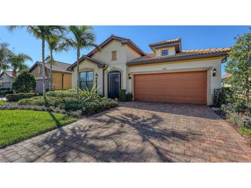 Charming home featuring a well-maintained lawn, beautiful landscaping, and a brick driveway at 17026 Loudon Pl, Bradenton, FL 34202