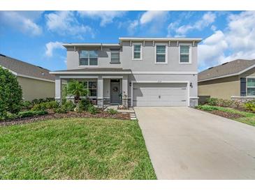 Charming two-story home with a well-manicured lawn and a welcoming front porch at 17119 Harvest Moon Way, Bradenton, FL 34211