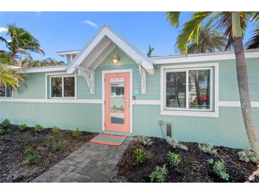 Charming beach house featuring a delightful coral-colored front door and serene, light blue exterior at 3007 Avenue E # A, Holmes Beach, FL 34217