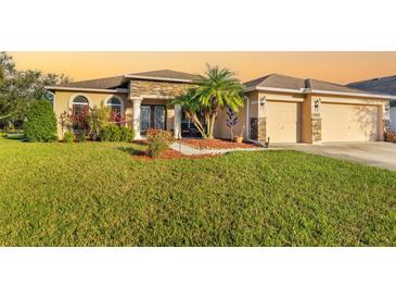 Beautiful single-story home with a lush green lawn, stone accents, and a two-car garage at 5814 117Th E Ter, Parrish, FL 34219