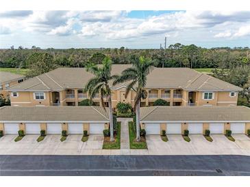 Aerial view of condo exterior and garages in a well-maintained community with mature trees at 6326 Grand Oak Cir # 203, Bradenton, FL 34203