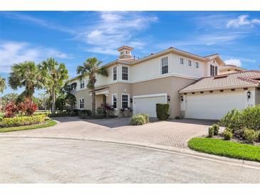 Elegant two-story home featuring a red tile roof, brick driveway, manicured landscaping and a two-car garage at 9415 Discovery Ter # 101A, Bradenton, FL 34212