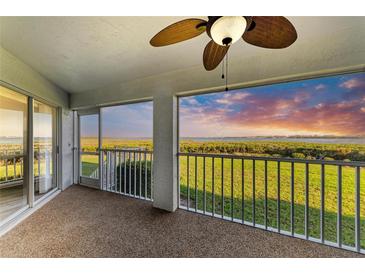 Screened lanai offering a tranquil view of lush green landscape with beautiful sunset at 1153 Edgewater Cir, Bradenton, FL 34209