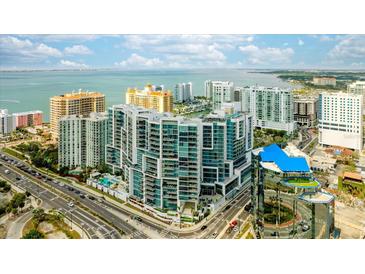 Stunning aerial view of a modern high-rise condominium building with waterfront views and cityscape at 1155 N Gulfstream Ave # 1709, Sarasota, FL 34236