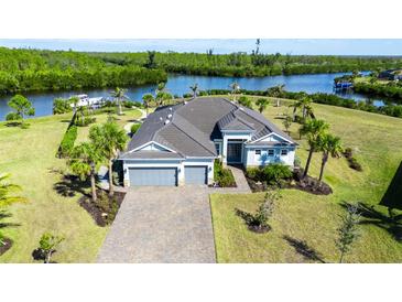 A beautiful waterfront home with a three-car garage and lush tropical landscaping at 14540 Gaspar Loop, Port Charlotte, FL 33981